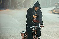 Ein Radfahrer hat ein Smartphone in der Hand während des Fahrens.