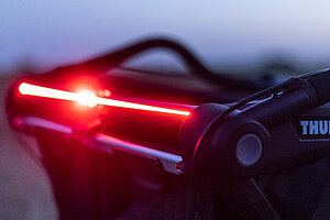 Leuchtender Streifen an Kinderanhänger von Thule in der Dämmerung