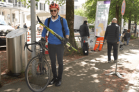 Mann mit Rennvelo und Langlaufskis am mobilen Recyclinghof.