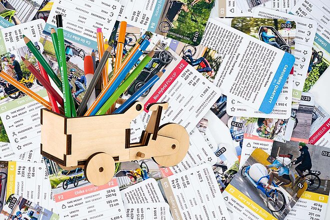 Ein Lastenrad aus Holz dient als Stifthalter. 