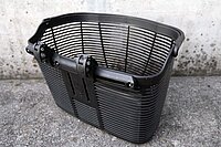 Ein Korb, der an den Gepäckträger eines Velos geklemmt werden kann