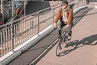 DB Brompton Faltrad-Abo. Ein Mann fährt auf einem Faltrad von Brompton.