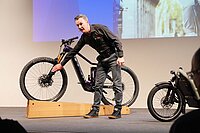 Bosch präsentiert an der Eurobike die neue Generation des Smart System. Ein Mann steht vor einem E-Mountainbike. 