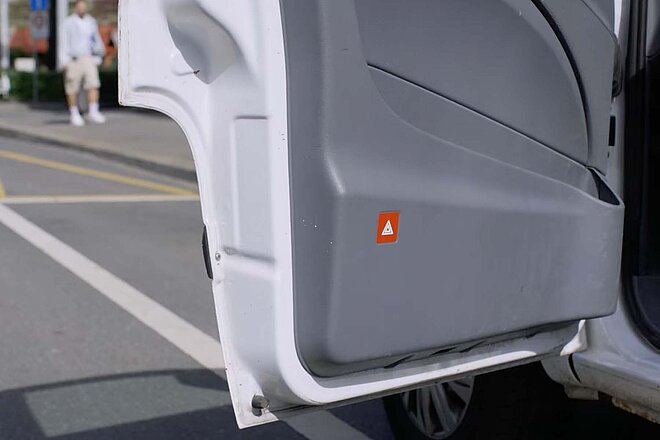 Dooring Kampagne TCS Pro Velo. Eine Autotür mit Knopf für Warnblinker.