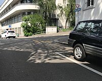 Eine Kreuzung mit Veloweg und Autos.