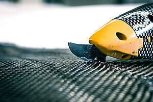 Radiate Engineering & Design. Ein Cutter schneidet ein schwarz schimmerndes Material. 