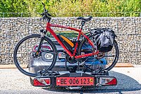 Ein Velo ist auf einem Heckträger am Auto montiert