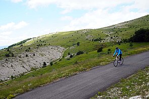 Ein Mann fährt mit dem Rennrad einen Berg hinunter