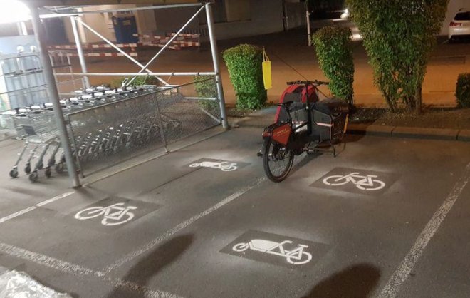 Frisch markierte Parkplätze für Cargobikes neben Einkaufswagen Station in der Nacht
