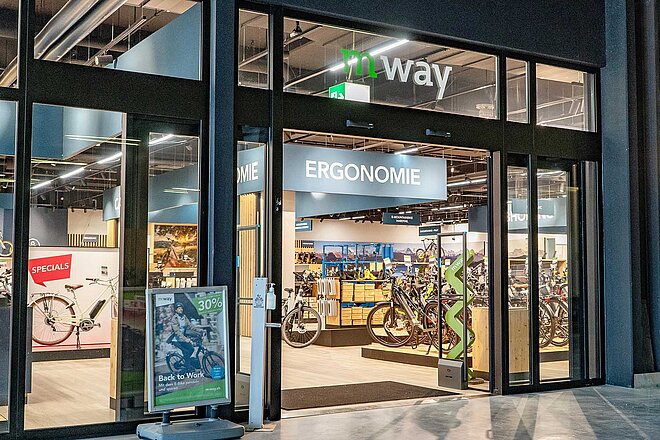 M-Way Bernexpo E-Bike Miete. Fensterfront eines Fahrradladens, der mit M-Way angeschrieben ist.