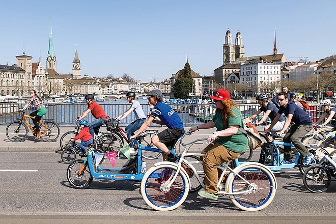 Die Cycle Week feiert im August das Velo. Und das gleich mehrere Tage lang. (Foto: ZVG) Ein bunter Tross von Menschen auf Velos, die in der Stadt Zürich über eine Brücke fahren.