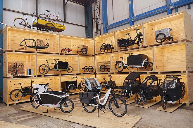 Velociped Cargobike-Center Kriens. Velos und Lastenräder stehen auf Holzpaletten. 