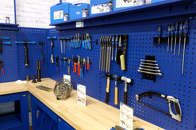 Werkzeuge hängen an einer blauen Wand.