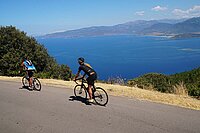 Mit dem Rennrad in Korsika. Zwei Personen mit Rennvelos auf einer Bergstrasse in Korsika.