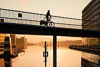 Eine Person fährt mit dem Velo über eine Brücke in Kopenhagen.