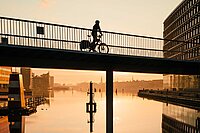Eine Person fährt mit dem Velo über eine Brücke in Kopenhagen.