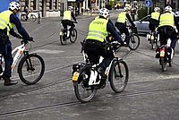 Repression an der Critical Mass in Zürich. Polizisten in Leuchtwesten fahren auf E-Bikes in der Stadt Zürich.