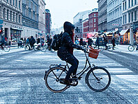 Frau auf dem Velo im Winter