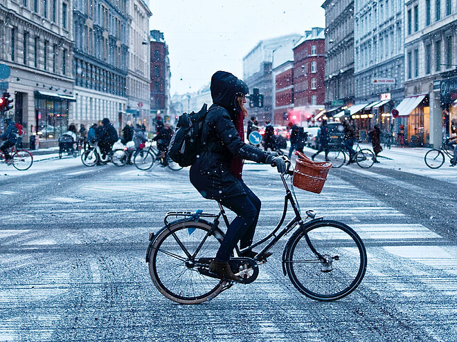 Frau auf dem Velo im Winter