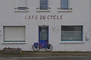 Ein Fahrrad steht vor der Tür eines alten Gebäudes in Frankreich.