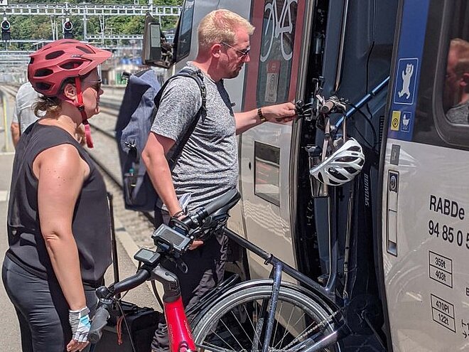 Frau und Mann laden Velo in Zug.
