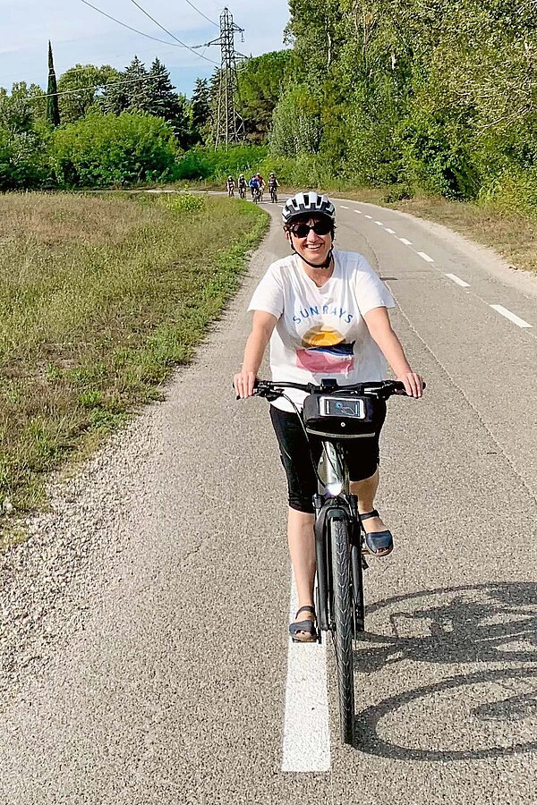 Eine Frau mit weissem T-Shirt auf dem Fahrrad.