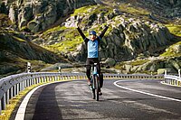 Ein Velofahrer streckt die Arme in die Höhe.