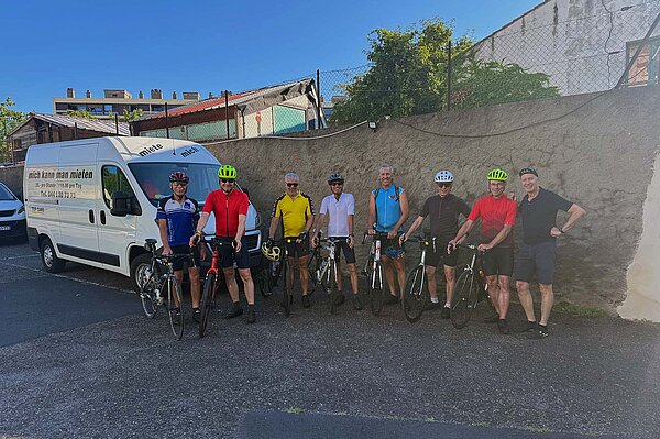 Eine Reisegruppe steht neben einem weissen Van.