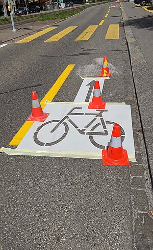 Wie das Astra den Veloverkehr fördern will. Ein Velosignet wird auf die Strasse gemalt.