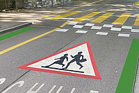 Velovorzugsroute mit grüner Markierung, achtung Schulkinder-Schild und Berliner Kissen