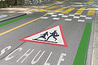 Velovorzugsroute mit grüner Markierung, achtung Schulkinder-Schild und Berliner Kissen