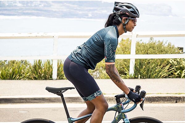 Frau auf Rennrad in tropischer Kulisse