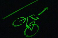 Ein Velosignet leuchtet in grüner Farbe in der Dunkelheit
