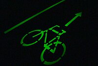 Ein Velosignet leuchtet in grüner Farbe in der Dunkelheit