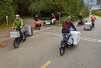 Albert Koechlin Stiftung subventioniert Cargobikes in der Innerschweiz. Personen fahren auf Latenrädern auf einer Strasse. 