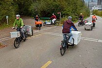 Albert Koechlin Stiftung subventioniert Cargobikes in der Innerschweiz. Personen fahren auf Latenrädern auf einer Strasse. 
