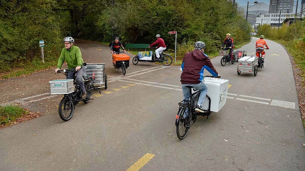 Albert Koechlin Stiftung subventioniert Cargobikes in der Innerschweiz. Personen fahren auf Latenrädern auf einer Strasse. 