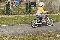 Ein Kind fährt auf einem Kinderad. 