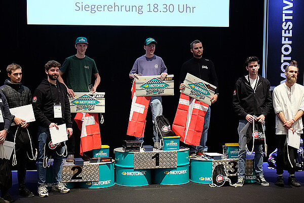 Die Schweizer Velomechaniker brillieren. Personen stehen auf einem Podest. 