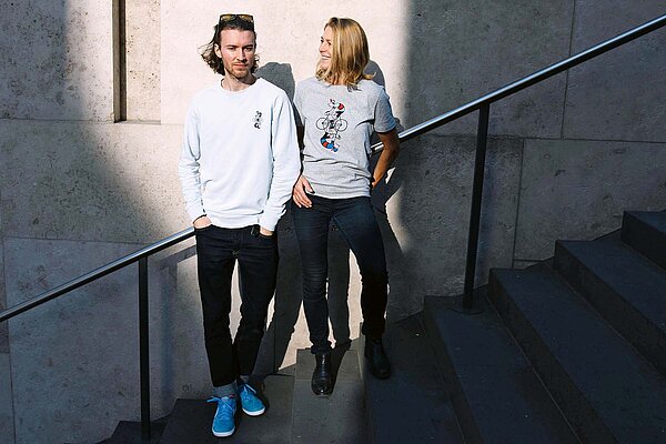Eine Frau und eine Frage tragen T-Shirts mit Velosymbolen