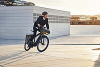 Marktbulletin Velohandel Schweiz 2023. En Mann fährt mit einem Fahrrad auf der Strasse.