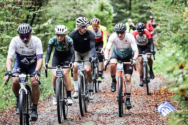 Gravel Ride & Race Bern. Frauen und Männer auf Gravelbikes im Wald.