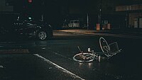 Velo liegt nach Unfall in der Dunkelheit vor einem Auto auf der Strasse