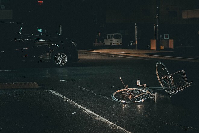 Velo liegt nach Unfall in der Dunkelheit vor einem Auto auf der Strasse