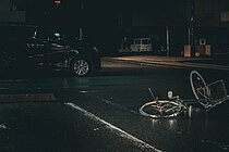 Velo liegt nach Unfall in der Dunkelheit vor einem Auto auf der Strasse