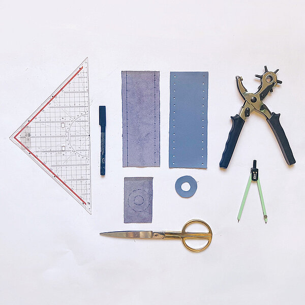 DIY-Velojournal Anleitung für Kerzenständer: Auslage Lederteile, Lochzange, Geodreieck und Schere vor weissem Hintergrund