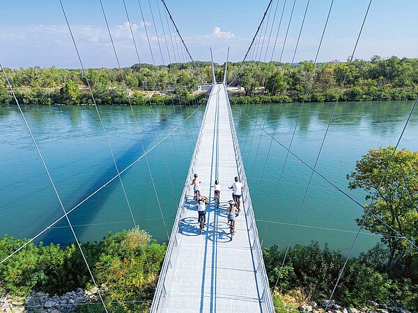 Eine Hängebrücke führt über einen Fluss.