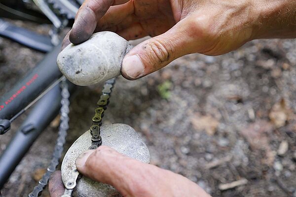 Fahrradpanne unterwegs kaputte Kette mit Stein nieten.