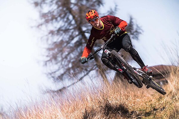 Ein Mountainbiker macht mit seinen Bike einen Sprung