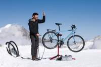 Ein Mann steht mit einem Fahrradständer im Schnee